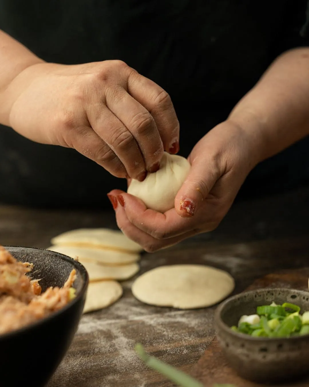 Hands folding dumplings in a restaurant kitchen, shot for Laotse